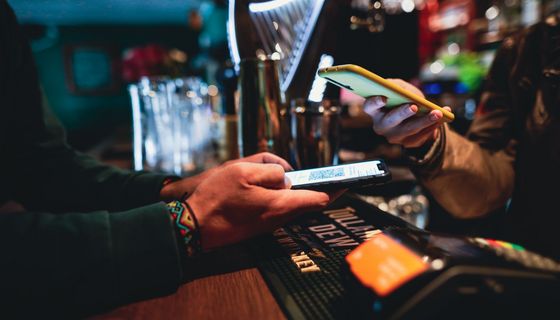 Barkeeper, scannt ein digitales Impfzertifikat.