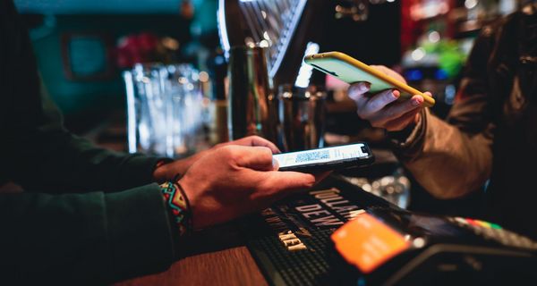 Barkeeper, scannt ein digitales Impfzertifikat.