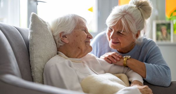 Frau, kümmert sich um eine Seniorin.