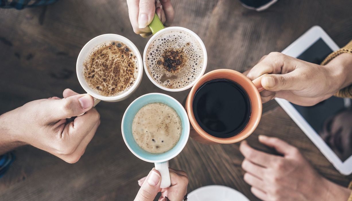 Vier Tassen mit Heißgetränken von oben, darunter Kaffee und Kakao.