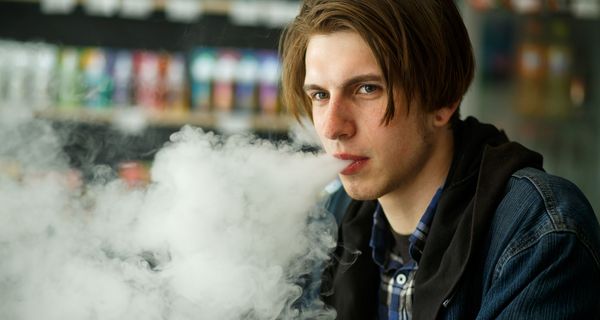 Jugendlicher dampft E-Zigarette.