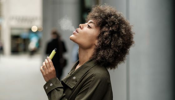 Junge Frau, nutzt eine E-Zigarette.