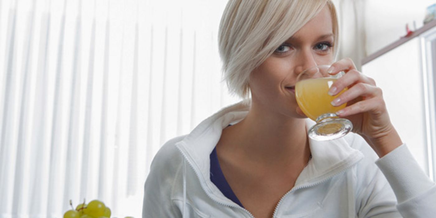 Junge Frau trinkt Saft.