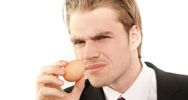Profilbild von einem Mann, der an einem Hühnerei riecht.