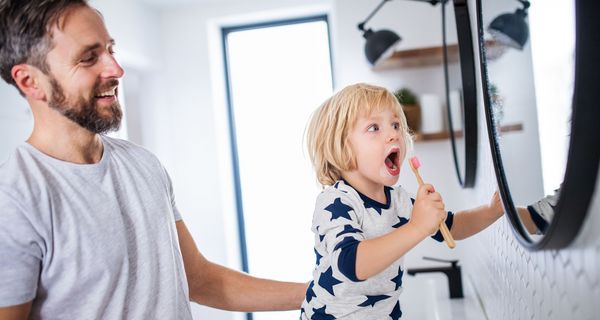 Vater mit kleinem Sohn beim Zähneputzen