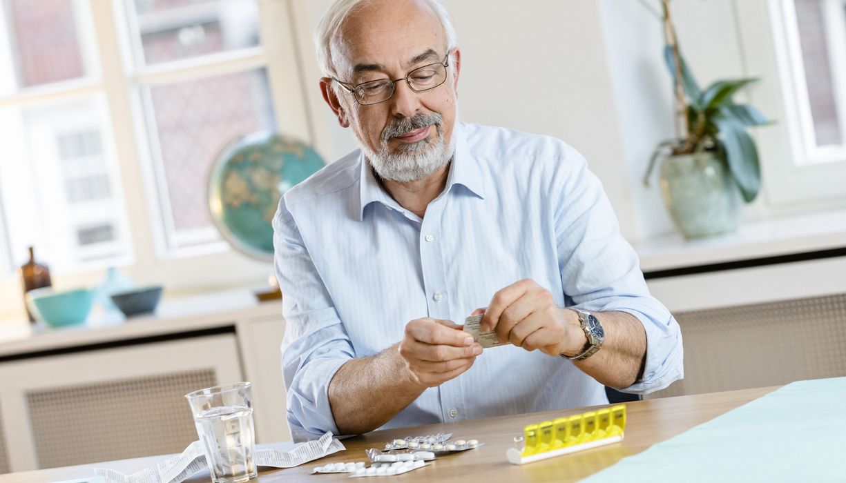 Älterer Mann mit mehreren Tabletten.