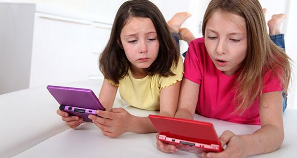2 Mädchen, ca. 9 und 11 (Geschwister?) spielen auf Videokonsolen