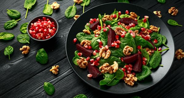 Salat aus Babyspinat, Walnüssen, Granatäpfeln und roter Beete.