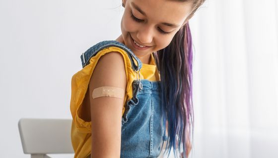 Mädchen hat ein Pflaster auf dem Arm