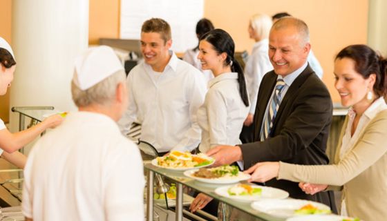 Fröhliche Menschen an der Essensausgabe einer Kantine