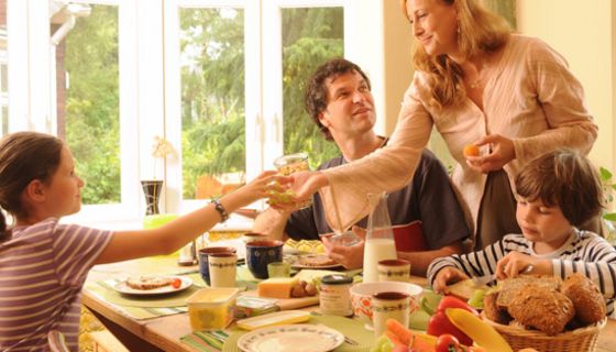 Familie: Vater, Mutter in den 30ern, Mädchen, ca. 10 Jahre, Junge ca. 7 Jahre, beim üppigen Frühstück