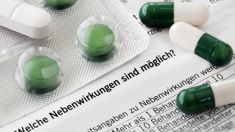 Grüne Tabletten auf Beipackzettel