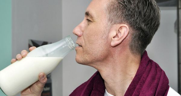 Mann trinkt aus Milchflasche.