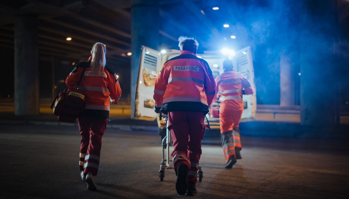 Notfallsanitäter, schieben eine Trage in das Einsatzauto.