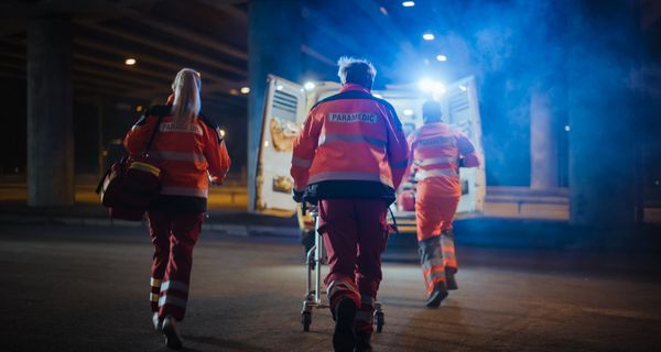 Notfallsanitäter, schieben eine Trage in das Einsatzauto.