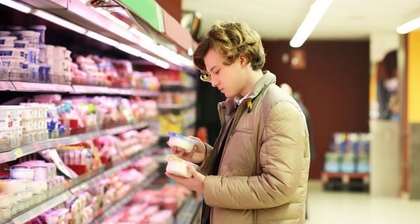 Junger Mann, betrachtet Lebensmittel im Supermarkt.