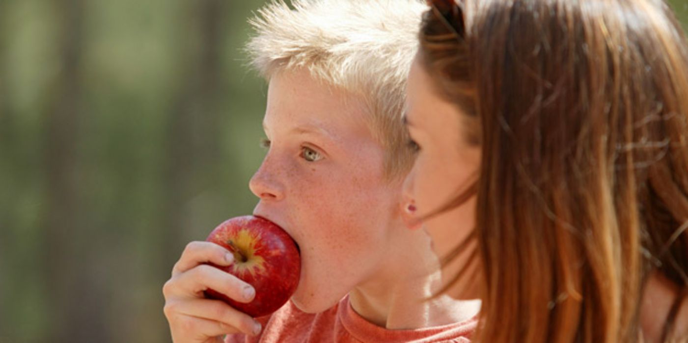 Junge isst Apfel.