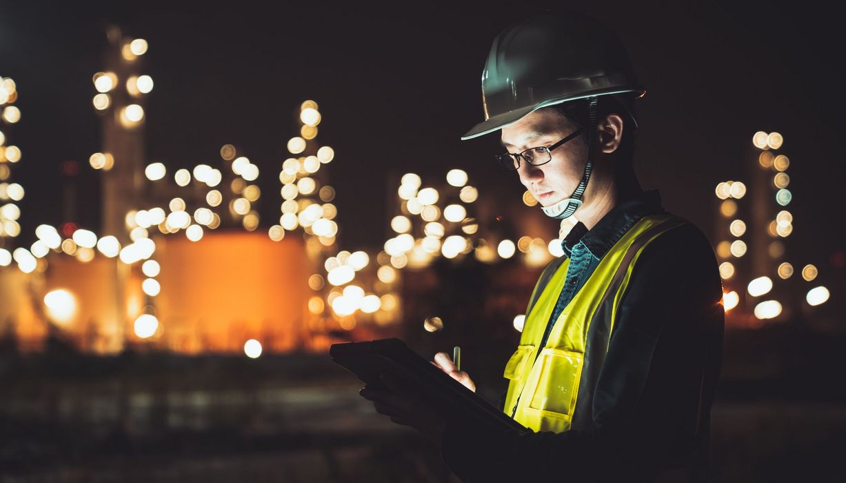 Mann, arbeitet nachts auf einer Baustelle.