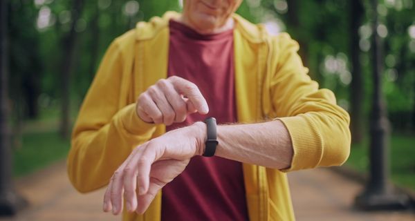 Mann, schaut auf seine Smartwatch.