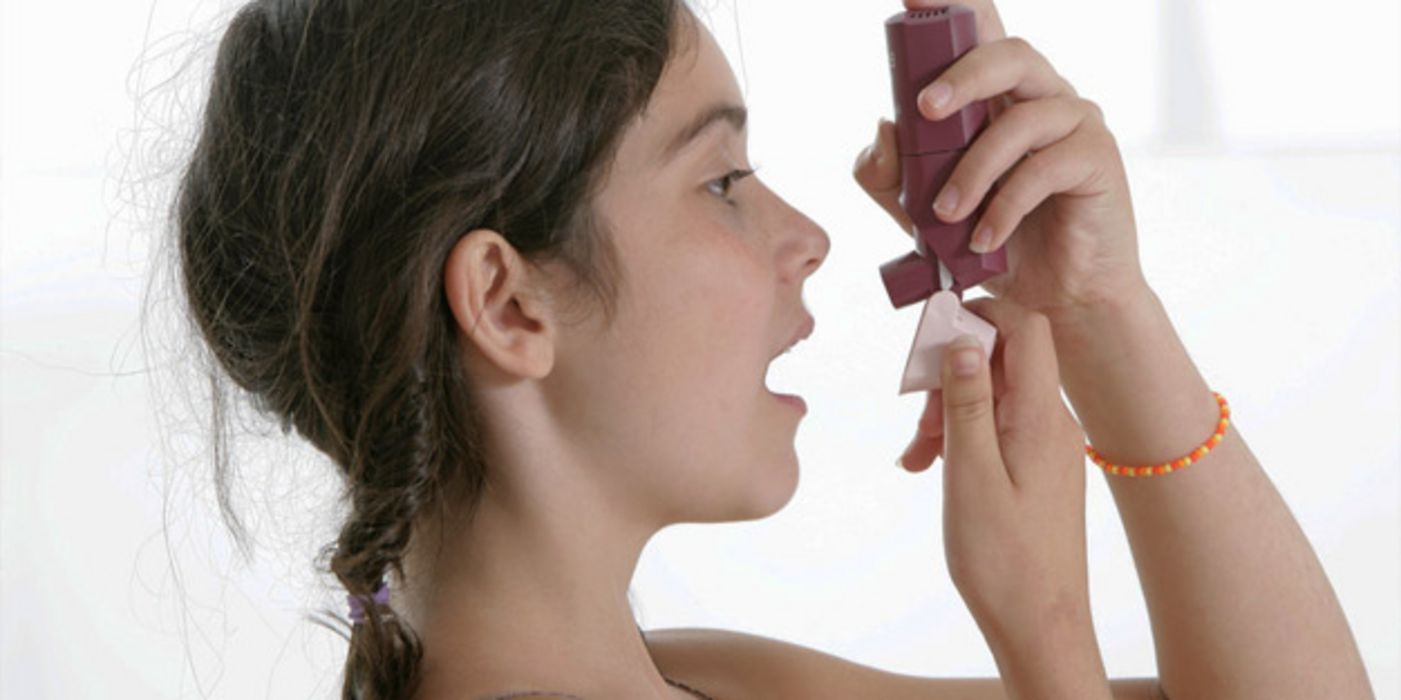 Junges Mädchen bei der Anwendung eines Asthma-Sprays