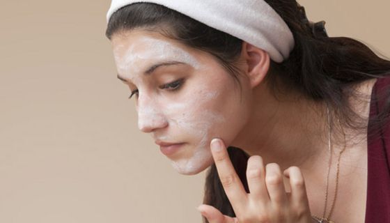 Junge Frau trägt eine Gesichtsmaske auf