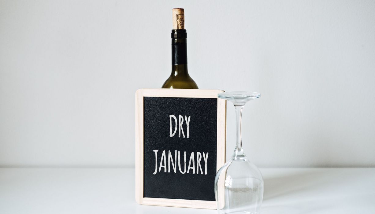 Schild mit der Aufschrift "Dry January" und einem umgekipptem Weinglas.