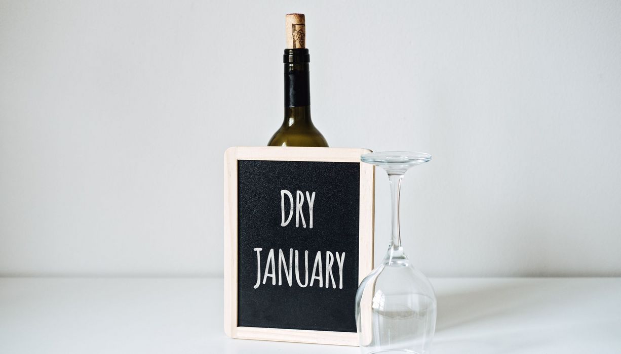 Schild mit der Aufschrift "Dry January" und einem umgekipptem Weinglas.