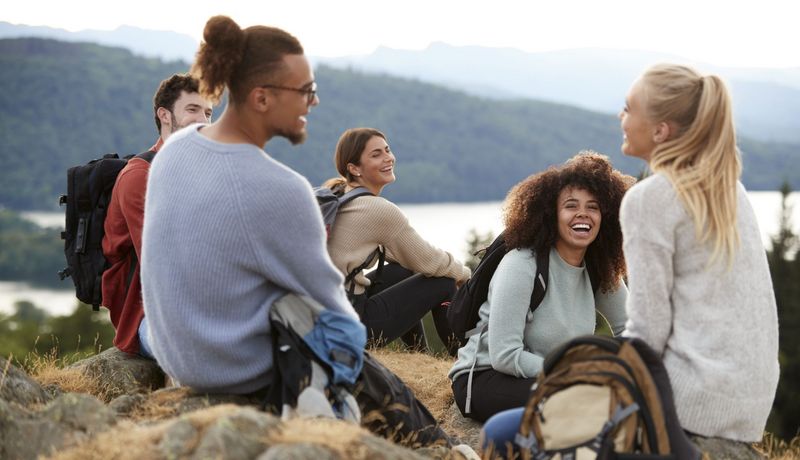 Junge Menschen rasten auf einer Wandertour.