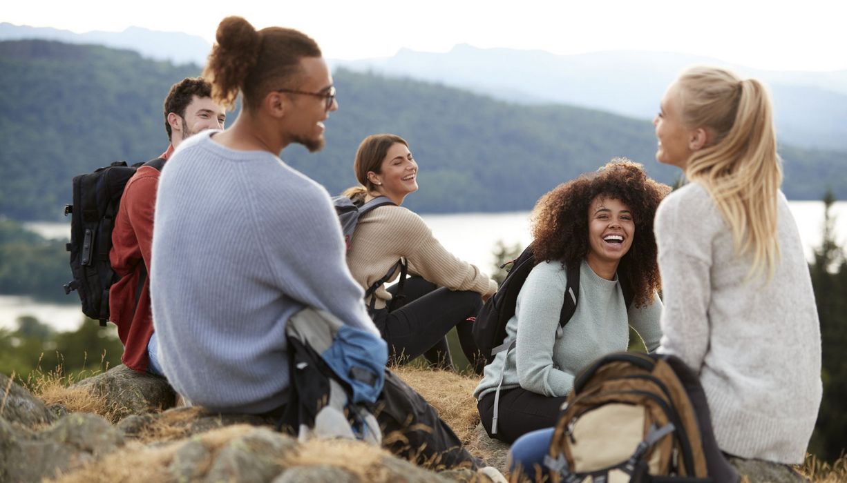 Junge Menschen rasten auf einer Wandertour.