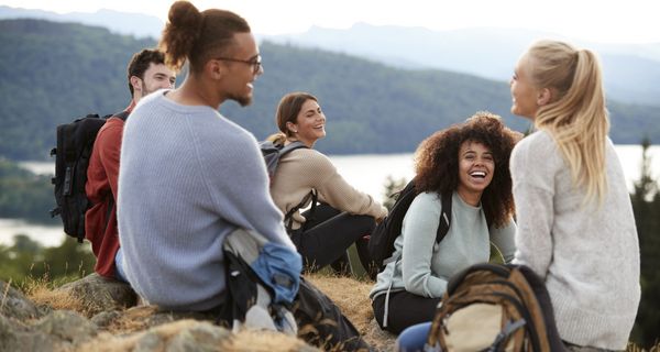 Junge Menschen rasten auf einer Wandertour.