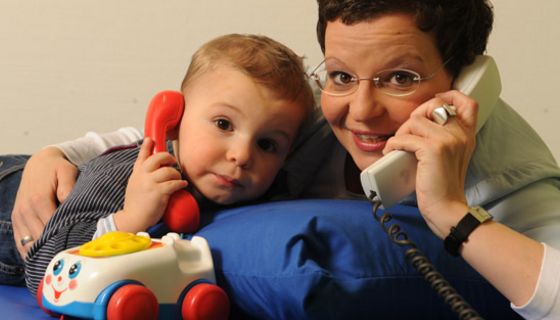 Kind und Mutter spielen mit dem Telefon.