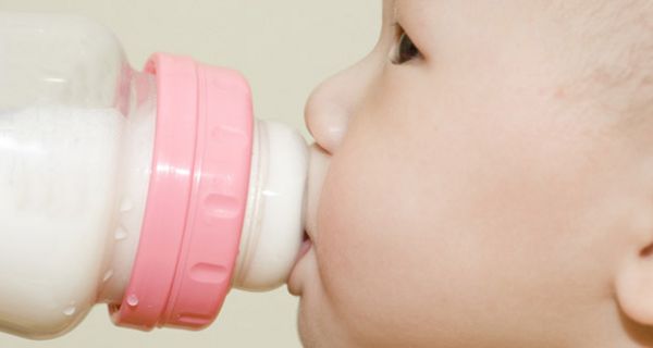 Baby trinkt aus einem Fläschchen Milch