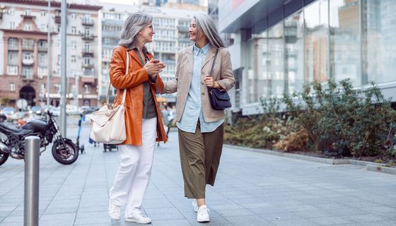 Zwei ältere Frauen schlendern durch eine Stadt.
