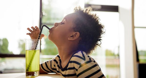 Kleiner Junge, trinkt einen Softdrink mit Strohhalm.