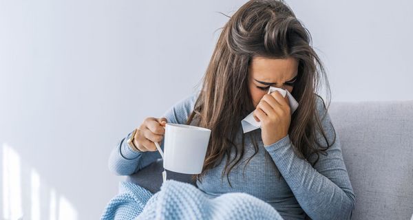 Frau liegt erkältet im Bett.