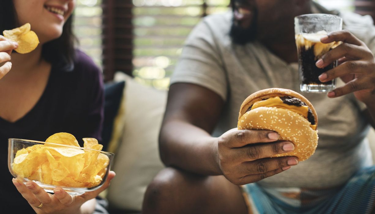 Übergewichtiger Mann und Frau, essen Fast Food.