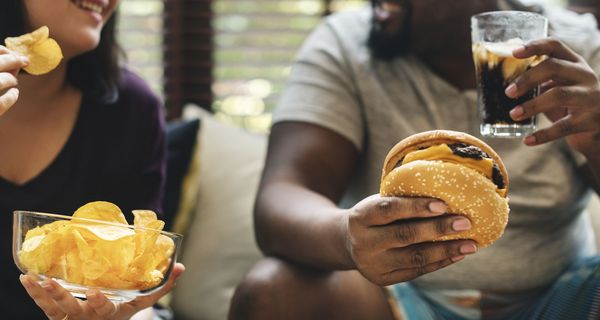 Übergewichtiger Mann und Frau, essen Fast Food.