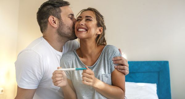 Junges Paar freut sich über positiven Schwangerschaftstest
