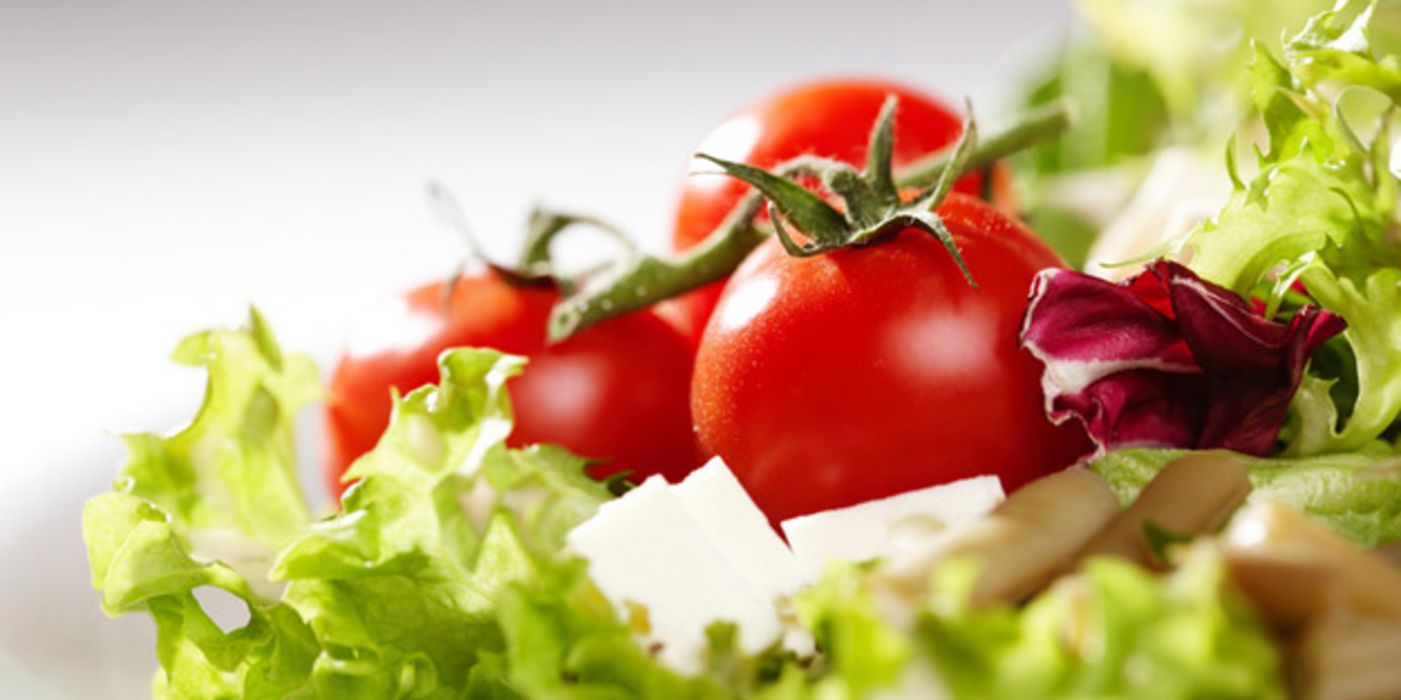 Salatteller mit ganzen Tomaten, Schafskäse und Blattsalaten