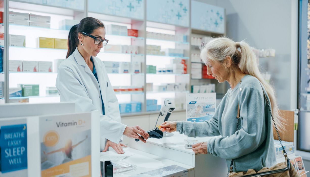 Frau, bezahlt in der Apotheke.