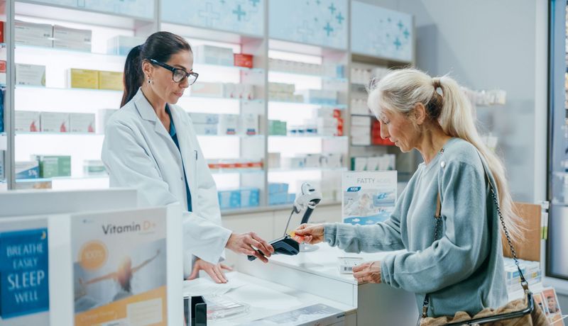 Frau, bezahlt in der Apotheke.
