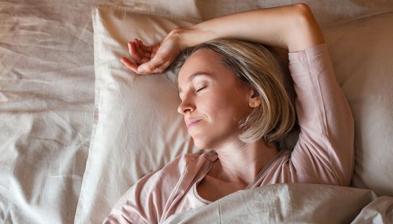 Frau, liegt im Bett und schläft. 