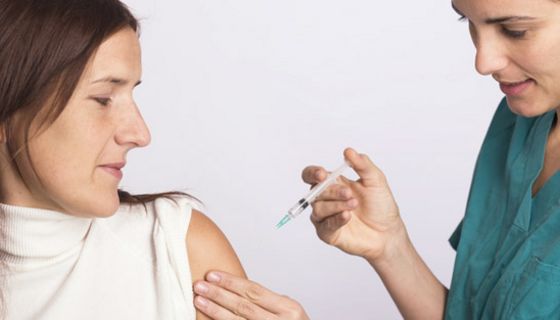 Krankenschwester impf Frau in den Oberarm