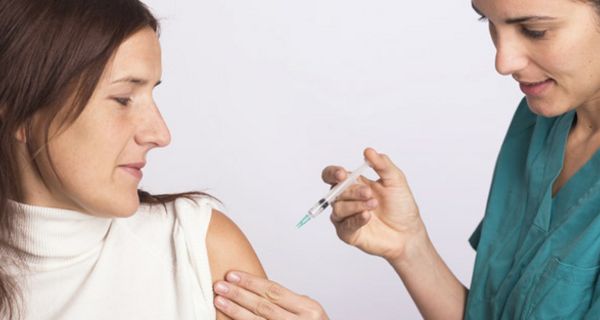 Krankenschwester impf Frau in den Oberarm