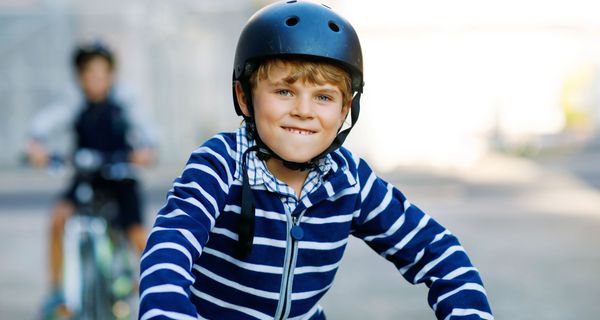 Junge mit Helm auf einem Fahrrad.