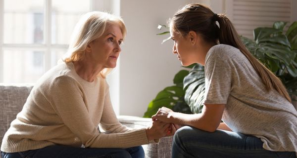 Zwei Frauen sitzen sich gegenüber und blicken sich an.