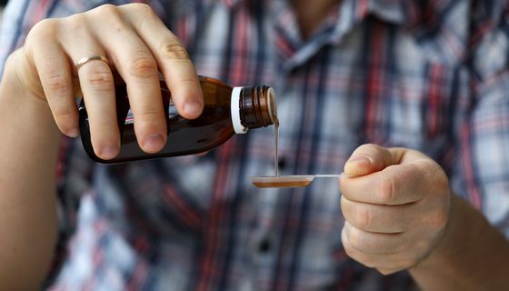 Mann, nutzt Hustensaft.