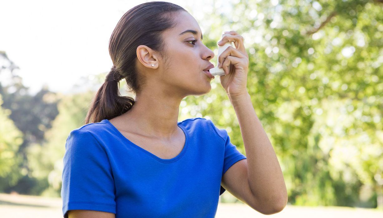 Junge Frau nutzt Asthmaspray.