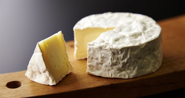 Angeschnittener Camembert-Käse auf einem Brett