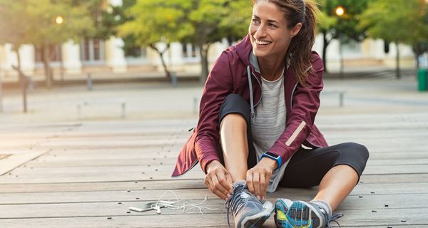 Joggerin bindet sich die Schuhe.